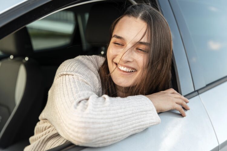 冒险笑脸女人在她的车里享受公路旅行旅行冒险旅行