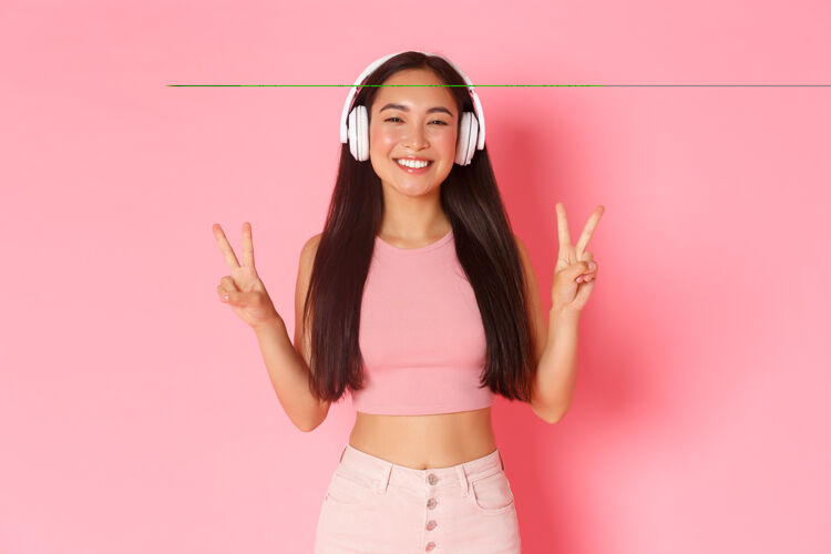 日语一个戴着耳机听音乐的富有表情的年轻女子跳跃搞笑女人