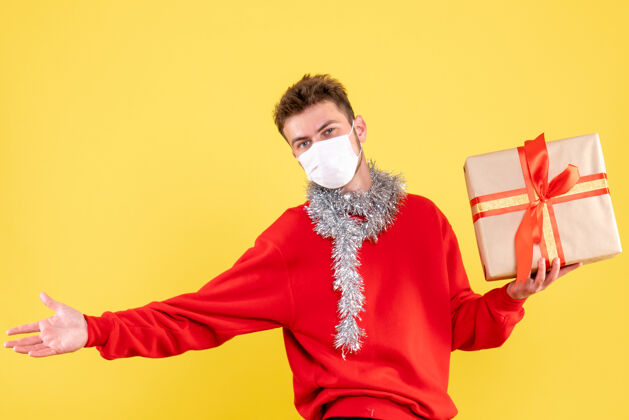 成人正面图：戴着无菌面具的年轻男性正在过圣诞节流行病人脸