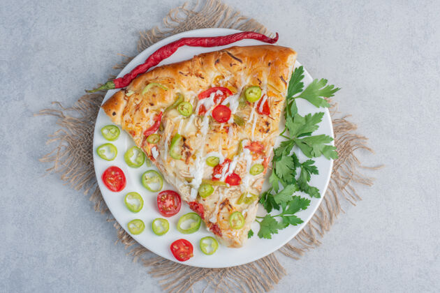 装饰一份比萨饼 上面有胡椒和欧芹叶 放在大理石表面美味切片胡椒