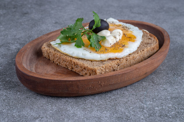 木头一块木板 上面放着美味的烤面包和煮鸡蛋高质量的照片橄榄煮熟木板