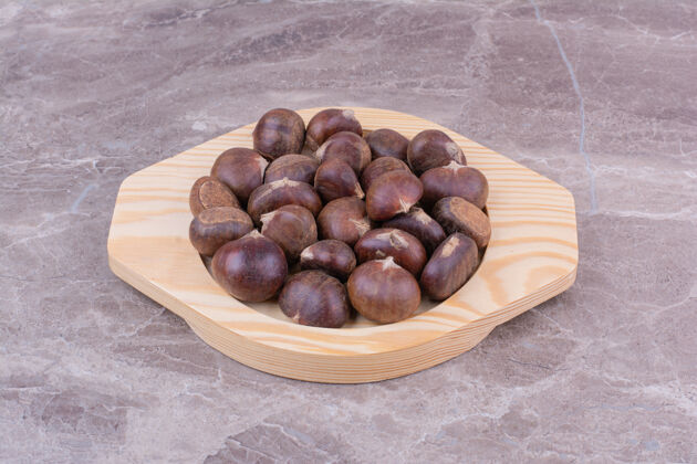 生物棕色栗子放在大理石上的木盘里热带清淡极简