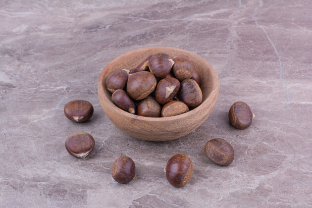 极简棕色栗子放在大理石上的木杯里美味食物清淡