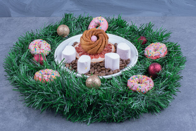 吃一个带甜甜圈和圣诞球的圣诞花圈谷物美味食物