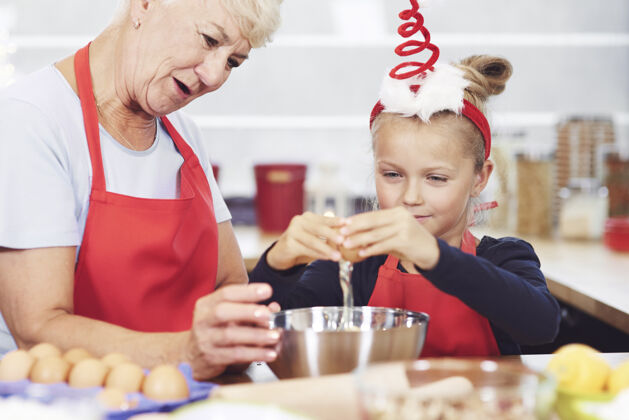 食物奶奶和孙女在厨房准备点心支持监督庆祝