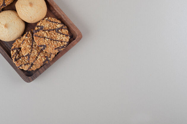 烘焙食品在大理石背景的小木托盘上放着各式各样的饼干烘焙美味托盘