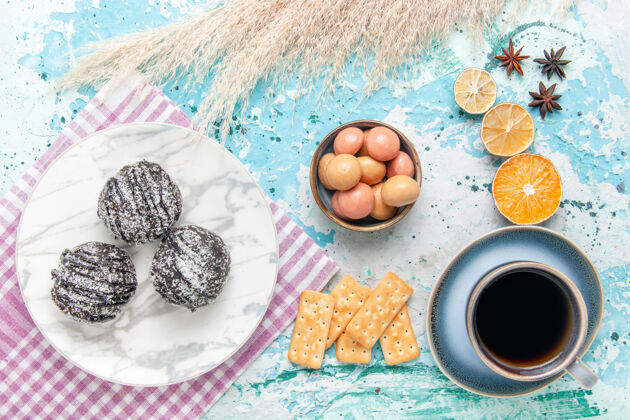生的俯瞰一杯咖啡 配巧克力糖霜蛋糕和薄脆饼干 背景为浅蓝色蛋糕 烘焙甜甜的糖派饼干派放松背景