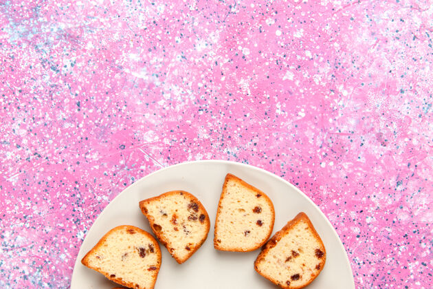 杯子顶视图蛋糕片与葡萄干内盘粉红色背景蛋糕烤甜饼干彩色糖饼干内部顶部视图