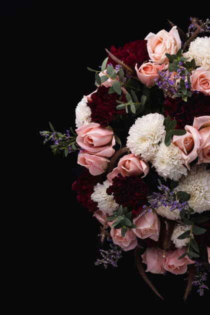 束一束奢华的粉红色和红色玫瑰和白色大丽花在黑色背景上的垂直拍摄开花植物自然
