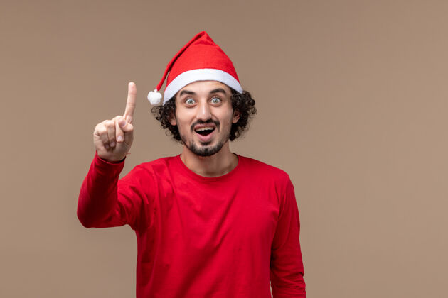 圣诞节正面图红色的男性在棕色背景上显示数字圣诞节快乐帅气职业