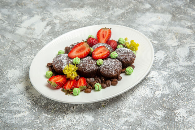 生的正面图美味的巧克力蛋糕 白色表面有新鲜草莓和巧克力片饼干巧克力甜蛋糕烘焙饼干浆果薯条烘焙