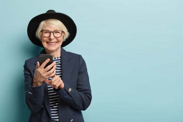 退休快乐的女性退休人员学习如何使用智能手机 打字通知乐观使用持有