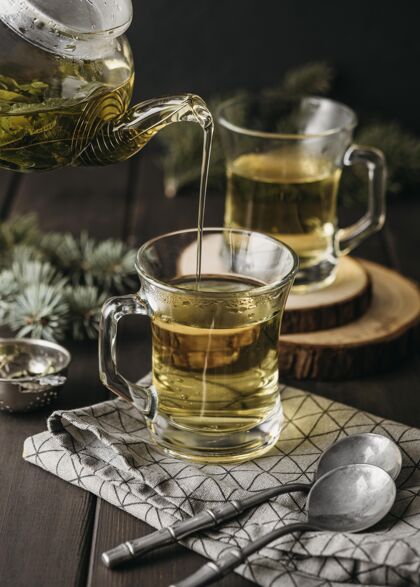 传统高角度手倒茶在玻璃与茶壶美味节日饮料