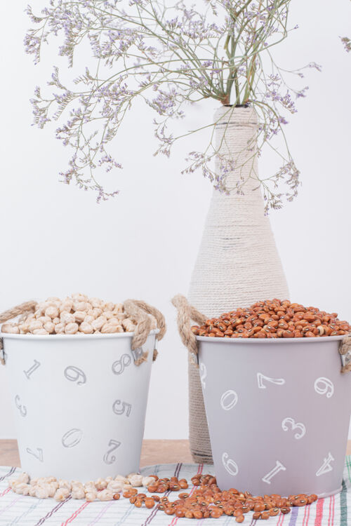 生的豆干和豌豆放在装满鲜花的桶里干食品有机食品桶装食品