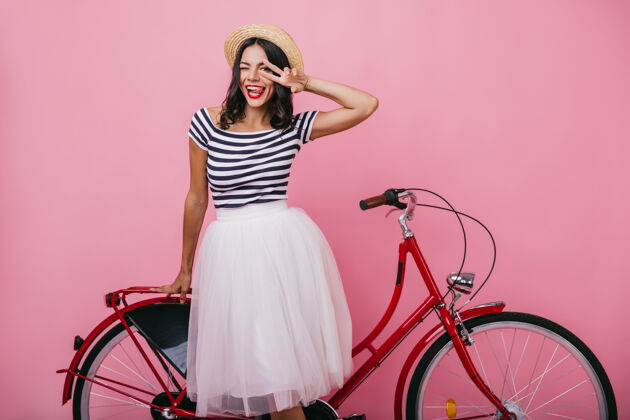 欧洲漂亮的拉丁女孩穿着华丽的裙子站在红色的自行车旁边穿着时髦衣服的可爱女人摆出愉快的姿势夏天服装可爱