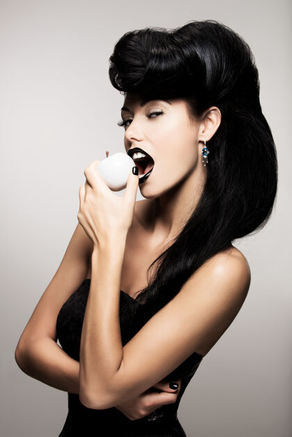 化妆品现代发型的时尚女性肖像咬白苹果性感戒指指甲