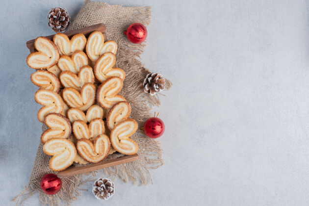 甜点成片的饼干堆在一个木篮子里 在大理石表面装饰着圣诞装饰品糖可口圣诞节