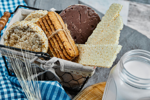 燕麦片大理石桌上放着一篮饼干和一罐牛奶 特写美食特写木头