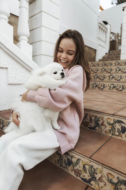 感情女孩和毛茸茸的狗在楼梯上小狗动物快乐