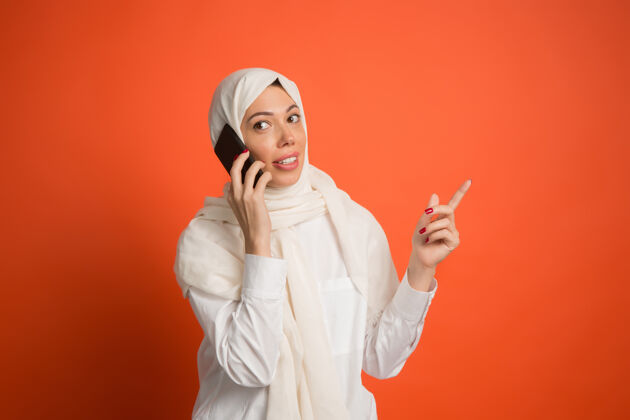 头巾快乐的阿拉伯女人戴着头巾拿着手机女性阿拉伯通讯