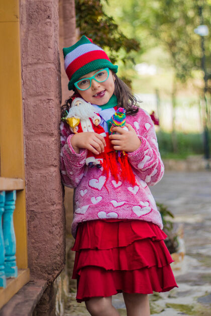 孩子可爱的女孩微笑着拿着她的圣诞老人玩具圣诞老人童年孩子