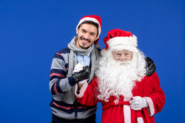 肖像前视图圣诞老人和年轻的男性庆祝圣诞老人服装