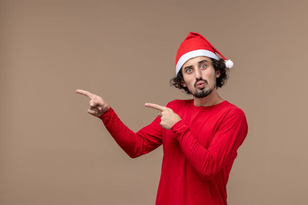 斗篷正面图：年轻男性 身穿深棕色背景的红色圣诞斗篷 感慨节日圣诞节背景观点帅哥