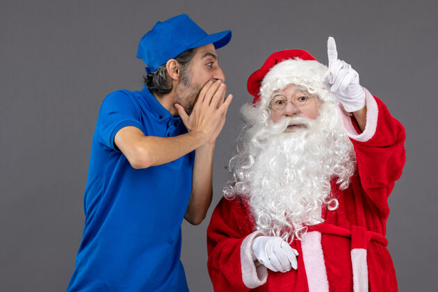 圣诞快乐灰色墙上的圣诞老人和男信使的正面图圣诞老人圣诞男人