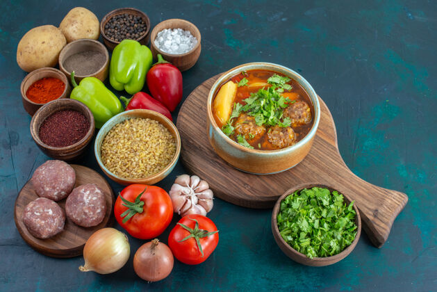 肉半俯视新鲜蔬菜和调味料肉汤和蔬菜在深蓝色桌子上蔬菜食物餐菜绿色新鲜调味品蔬菜