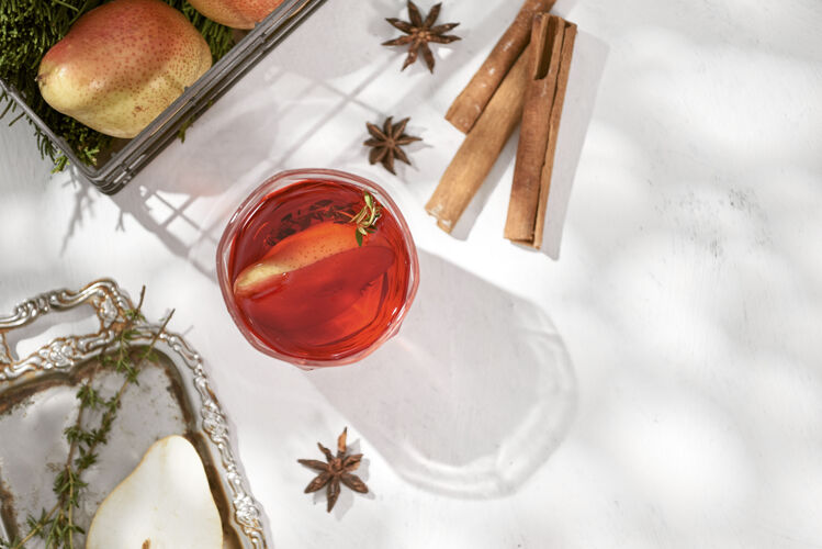 冬季美味 辛辣 热腾腾的红酒 配以肉桂 八角茴香和梨片 盛在一瓶和玻璃杯中 是寒冷的冬夜或节日的饮料秋季苹果酒梨