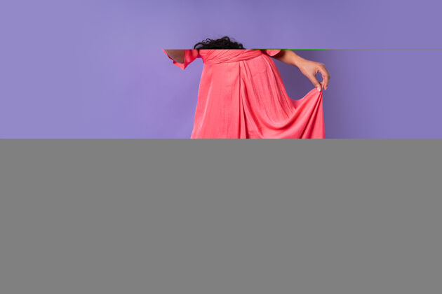 蓝色一位年轻快乐的巴西女性 卷发 穿着粉色时髦的裙子 拿着一杯咖啡摆姿势紫色墙壁上的香槟派对气氛非洲优雅头发
