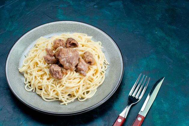 生的前视图煮熟的意大利面食与切片肉在盘子里蓝色表面意大利面食意大利餐面团肉面团调味品意大利酱