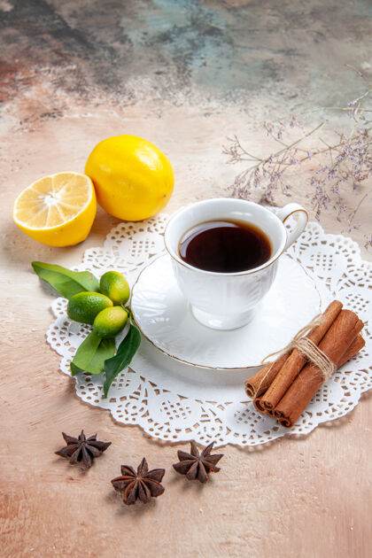 咖啡一杯红茶放在装饰好的餐巾上 水果肉桂放在五颜六色的桌子上药草茶肉桂红茶