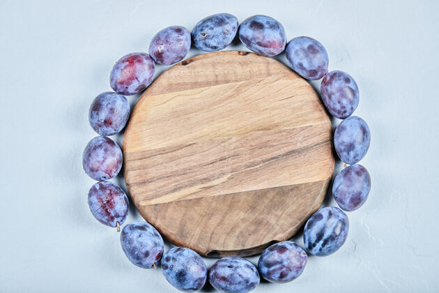 浆果一组新鲜的李子围在木板上高质量的照片美味李子健康
