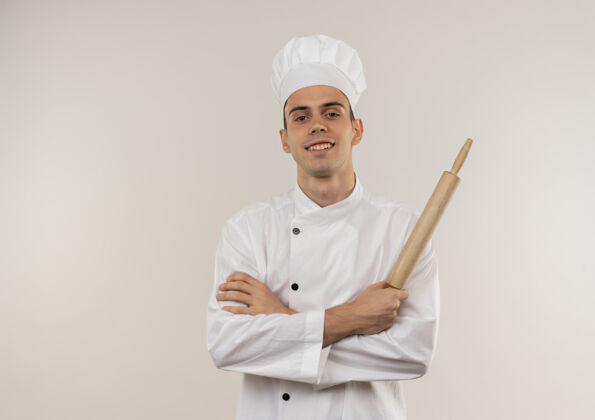 厨师面带微笑的年轻男厨师穿着厨师制服双手交叉拿着擀面杖与复印空间手厨师别针