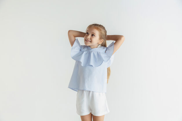 休闲时尚的微笑小女孩穿着休闲装在白色的工作室里成功开朗可爱