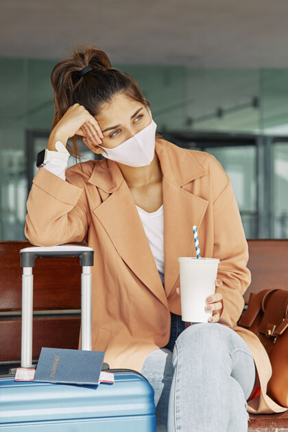 远足大流行期间 一名妇女戴着医用口罩在机场休息Ncov女性病毒