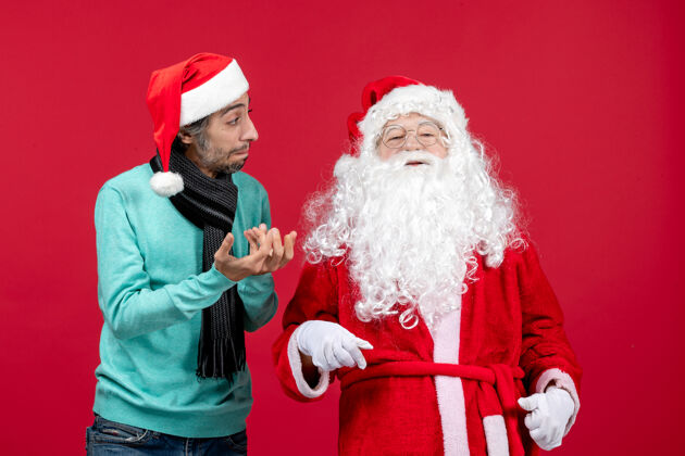 站立正面图：圣诞老人和年轻的男性站在一起圣诞老人圣诞帽子