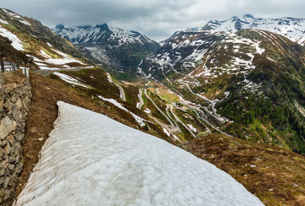 风景夏季高山景观与蜿蜒的高山公路（格里姆塞尔山口 瑞士）雪阿尔卑斯山风景
