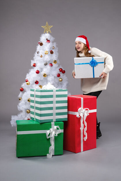 包圣诞礼物点亮的年轻女性圣诞帽礼物灯