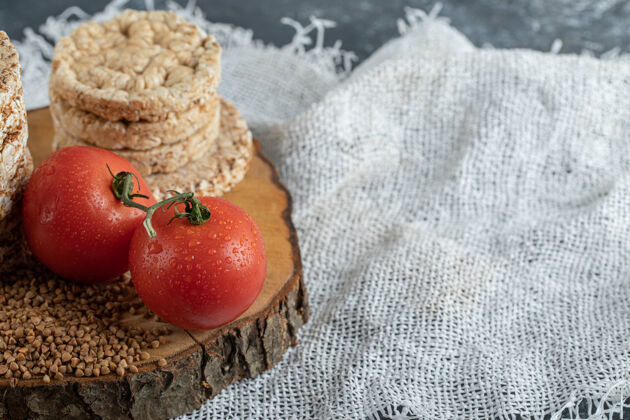 圆形美味的年糕 西红柿和生荞麦放在木片上脆的食物脆的