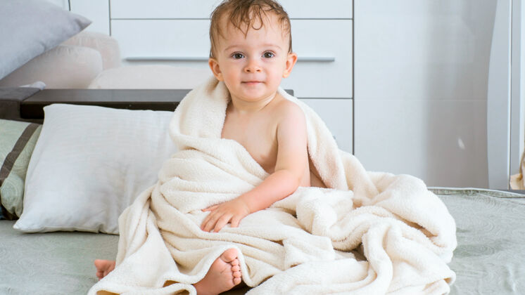 快乐坐在床上洗完澡后可爱的小男孩的画像水小毯子