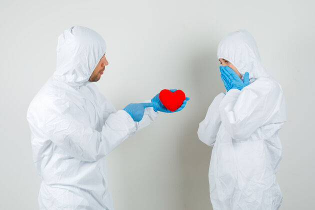 医院两个医生穿着防护服 戴着手套 互相送红心严重诊所西装