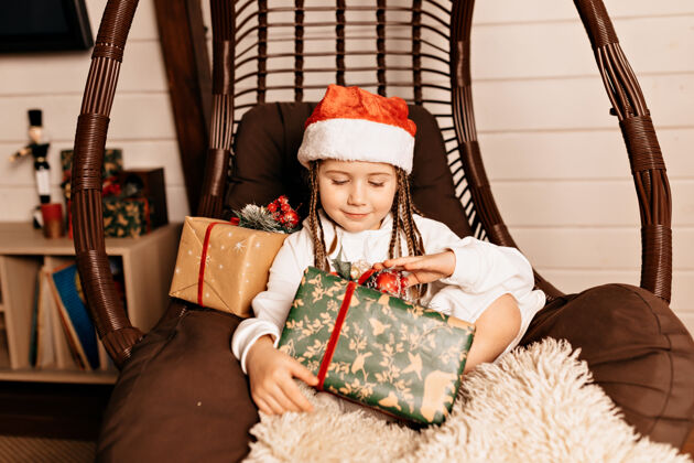 礼物有圣诞礼物的快乐女孩椅子孩子快乐