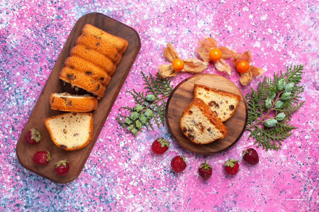鞋子美味蛋糕的俯视图甜美可口 粉红色表面上有新鲜的红色草莓切片新鲜烘焙饼干