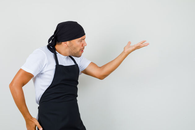 男性面包师穿着t恤 围裙 做着提问的手势 看起来很生气职业工人男人