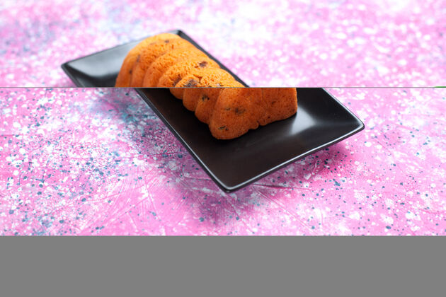 甜点正面是粉红色桌子上的黑色蛋糕锅里美味的烤蛋糕食物糖黑色