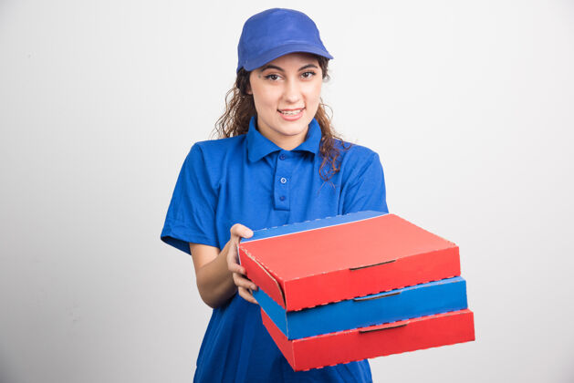 女性送比萨饼的女孩拿着三个白色背景的盒子高质量的照片帽子工人年轻人