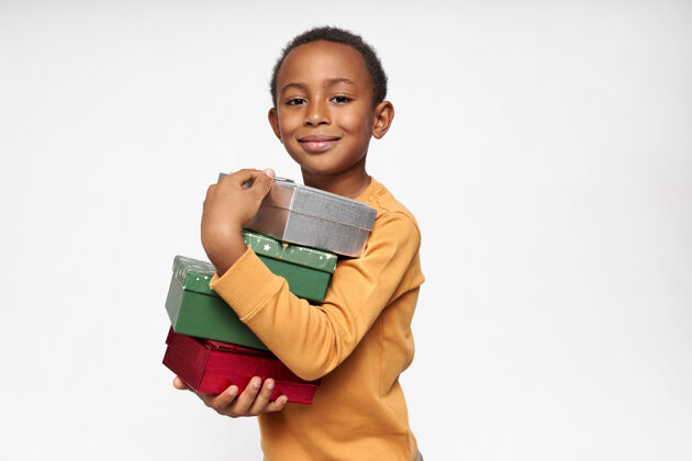 黑色一幅欢快的非洲男孩背着盒子 接受礼物 面带喜悦的微笑看着前方的画像生日庆祝小