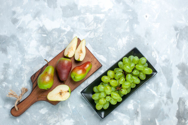 新鲜顶视图新鲜梨和浅白色背景上的绿色葡萄梨芒果水果